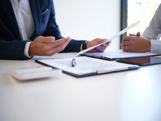 Two businesspeople reviewing documents in an office.